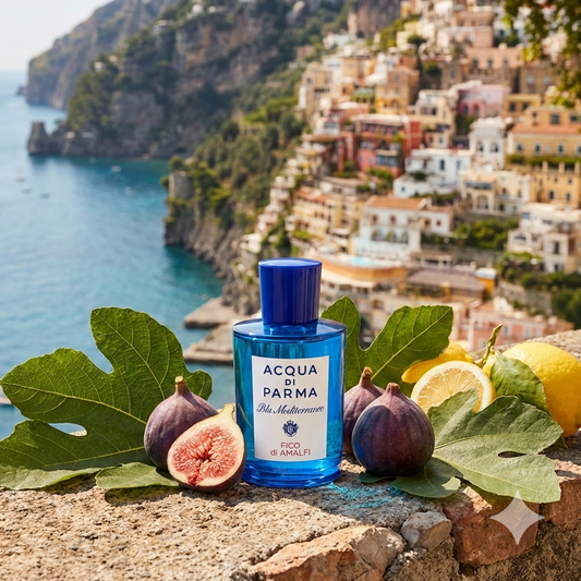 Frasco azul del perfume Acqua di Parma Fico di Amalfi rodeado de higos frescos, hojas verdes y cítricos con la costa amalfitana de fondo.