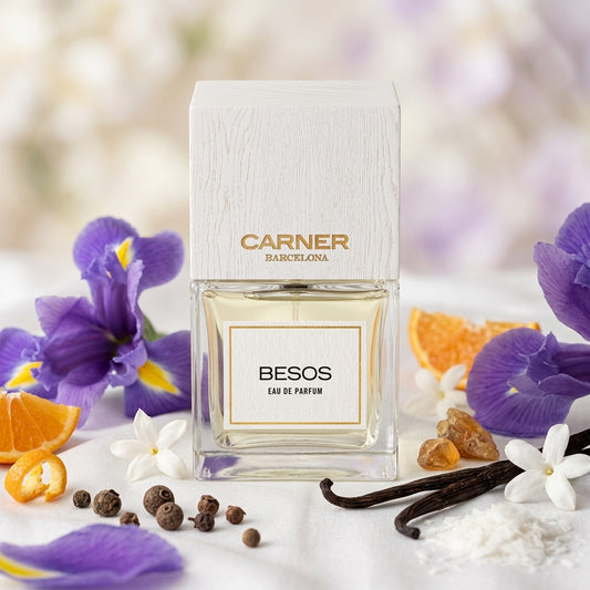 Frasco clásico de Besos de Carner Barcelona con tapón de madera blanca sobre seda con flores de iris, jazmín sambac y vainilla, estilo Casa Flores.