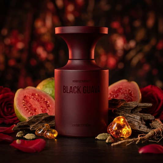 Frasco borgoña mate de BORNTOSTANDOUT Black Guava sobre madera oscura con guayaba, oud, cardamomo y resina de ámbar, estilo Casa Flores.