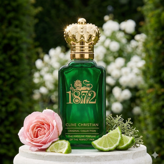 Frasco verde de Clive Christian 1872 Feminine rodeado de rosas blancas y cítricos frescos, estilo Casa Flores.