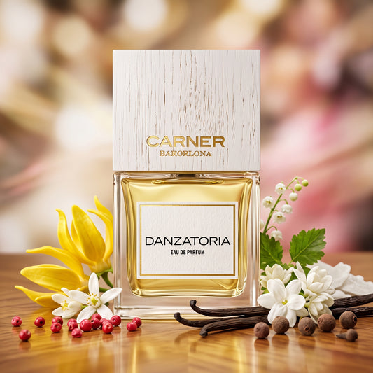Frasco clásico de Danzatoria de Carner Barcelona con tapón de madera blanca sobre madera cálida con flor de azahar, ylang-ylang y pimienta rosa, estilo Casa Flores.