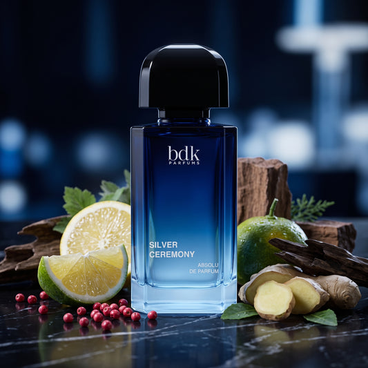 Frasco azul oscuro de Silver Ceremony de BDK Parfums con tapón negro sobre mármol negro con limón italiano, jengibre y madera de oud, estilo Casa Flores.